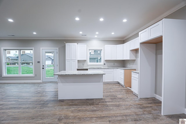 kitchen featuring white cabinets, a center island, recessed lighting, and ornamental molding