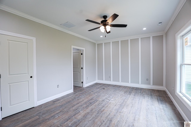 unfurnished bedroom featuring wood finished floors, visible vents, crown molding, and baseboards