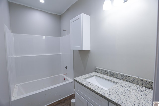 full bath with shower / bathing tub combination, wood finished floors, vanity, and recessed lighting