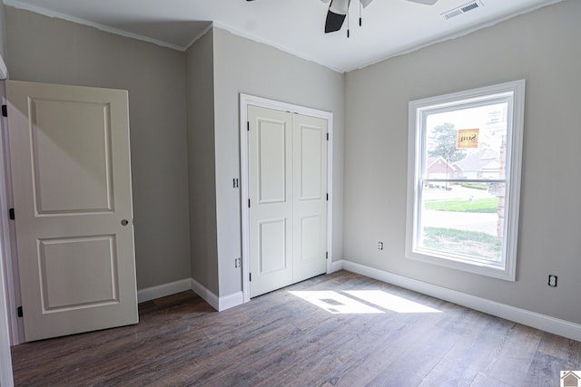unfurnished bedroom with baseboards, wood finished floors, and visible vents