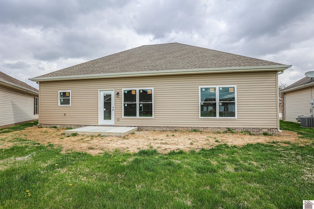 rear view of property featuring cooling unit, a yard, a patio area, and a shingled roof