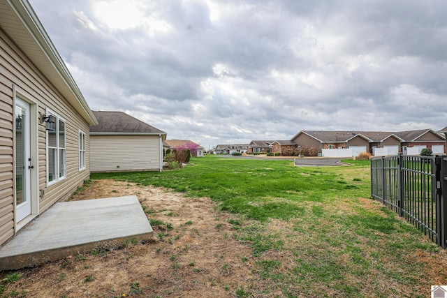 view of yard featuring fence, a residential view, and a patio