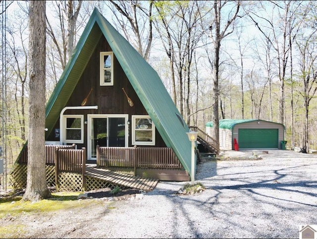 a-frame style home featuring an outdoor structure, a deck, metal roof, and a garage