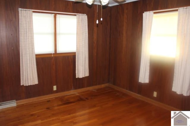 557 Doyle Rd, Hickory, KY 42051 - empty room featuring wooden walls, baseboards, a ceiling fan, and wood finished floors