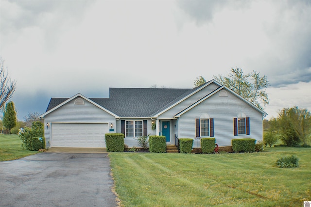 ranch-style house featuring roof with shingles, driveway, an attached garage, and a front lawn