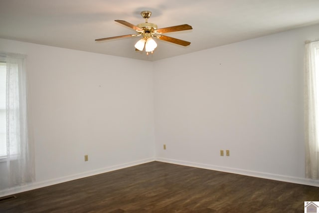 spare room with visible vents, ceiling fan, baseboards, and dark wood-style floors