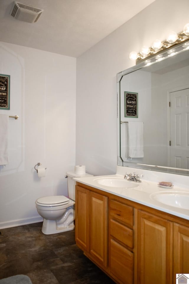 bathroom with visible vents, a sink, double vanity, and toilet