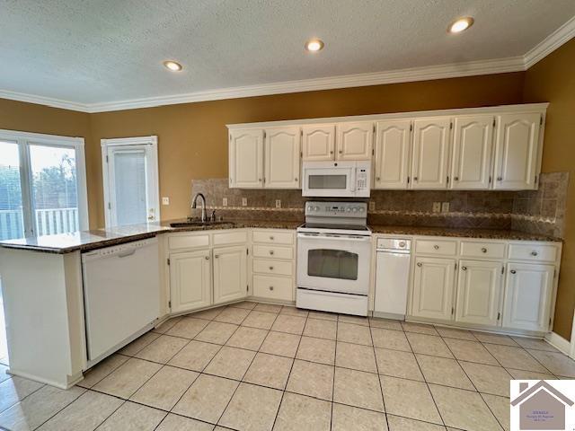 kitchen with a sink, decorative backsplash, white cabinetry, and white appliances