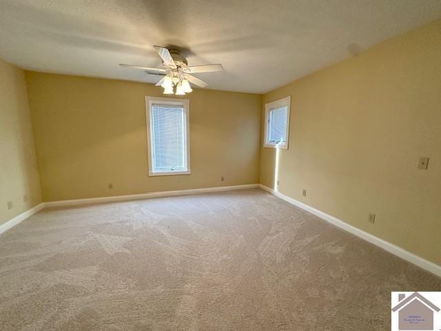 spare room featuring carpet flooring, baseboards, and a ceiling fan