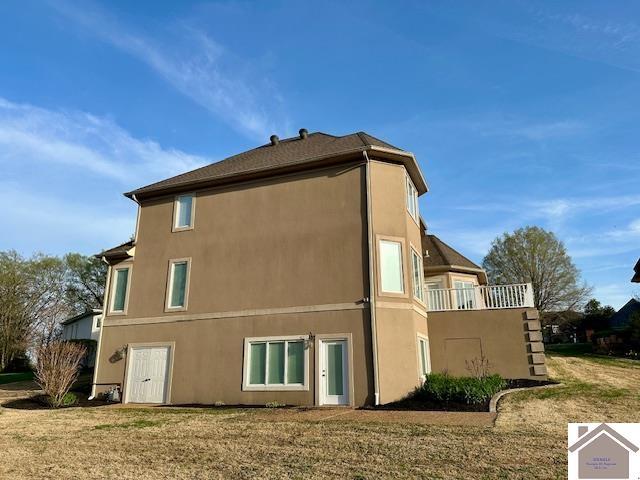 view of side of property with a yard and stucco siding
