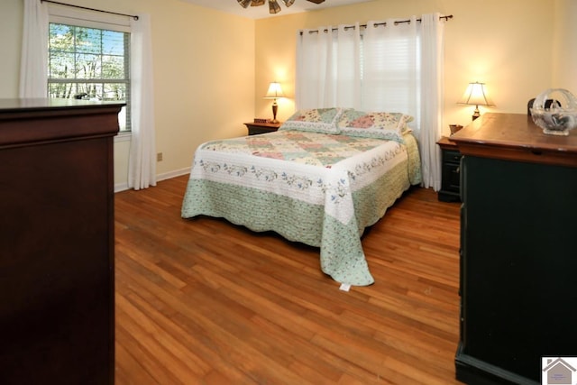 bedroom with wood finished floors and baseboards