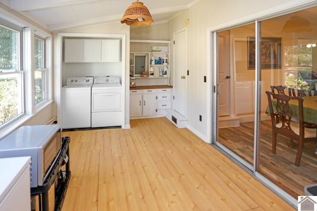 laundry room with light wood-type flooring, cabinet space, and washer and clothes dryer