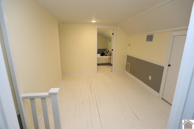 bonus room featuring light wood-style flooring, baseboards, vaulted ceiling, and visible vents