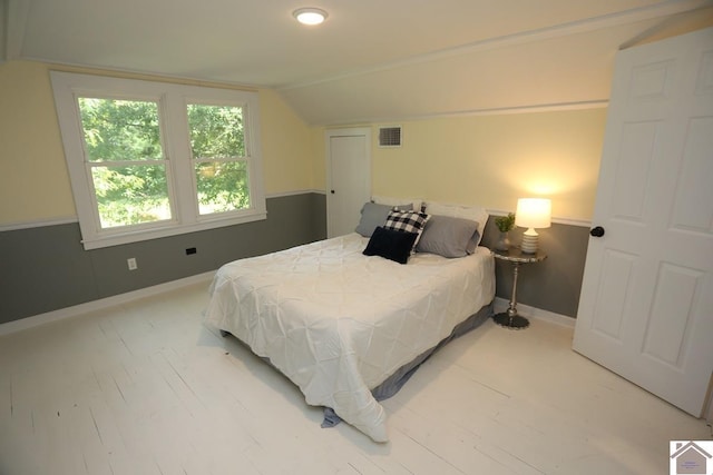 bedroom with baseboards, vaulted ceiling, and visible vents