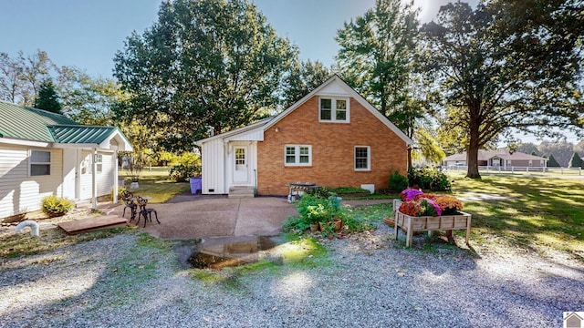 view of property exterior with entry steps, a yard, fence, a patio, and brick siding