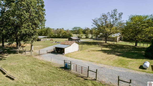 view of community with a yard, fence, an outbuilding, and a gate