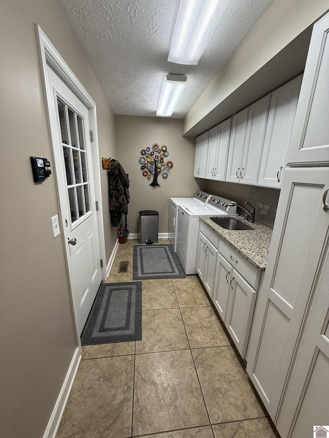 6060 State Route 94 W, Murray, KY 42071 - laundry room featuring light tile patterned floors, a textured ceiling, independent washer and dryer, cabinet space, and a sink