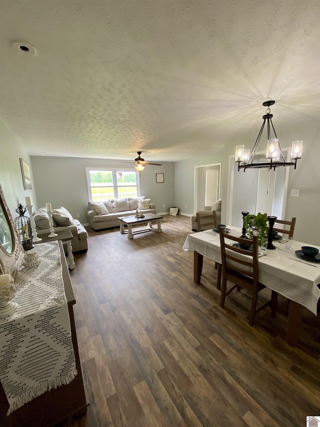 115 Marsha Dr, Ledbetter, KY 42058 - living room featuring a textured ceiling, baseboards, ceiling fan with notable chandelier, and dark wood-type flooring
