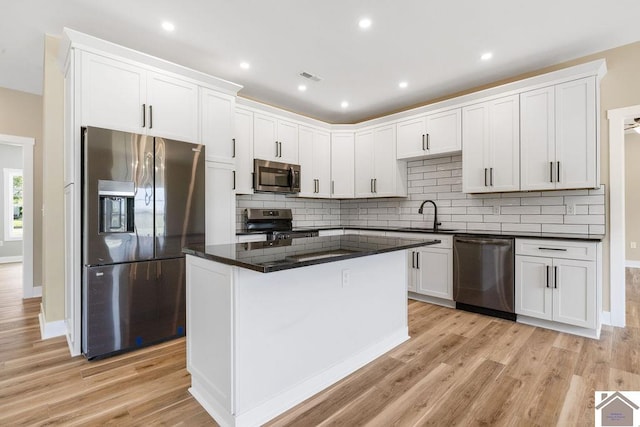 102 Ironwood Dr, Murray, KY 42071 - kitchen with a sink, visible vents, light wood-style floors, decorative backsplash, and appliances with stainless steel finishes