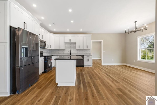 102 Ironwood Dr, Murray, KY 42071 - kitchen with dark countertops, light wood-style floors, stainless steel appliances, backsplash, and baseboards