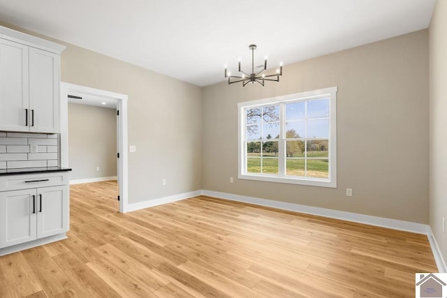 102 Ironwood Dr, Murray, KY 42071 - unfurnished dining area featuring baseboards, an inviting chandelier, and light wood-style floors