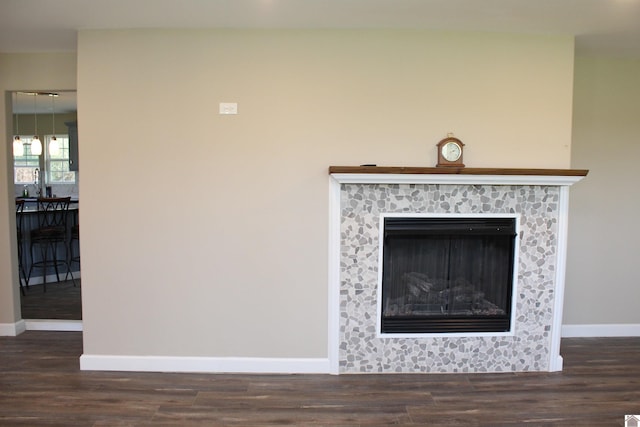 details featuring a fireplace, baseboards, wood finished floors, and a sink