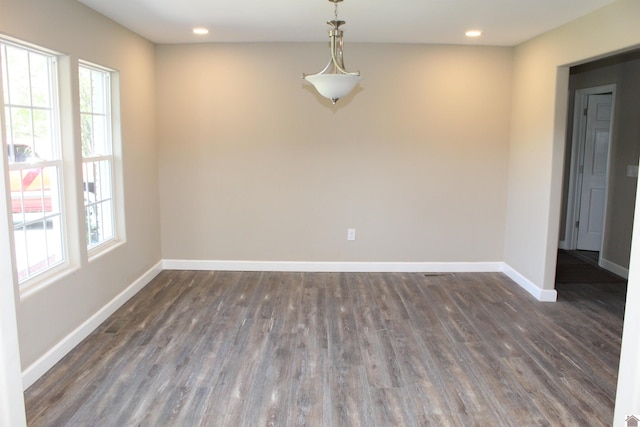 unfurnished room featuring recessed lighting, a healthy amount of sunlight, baseboards, and dark wood-style flooring