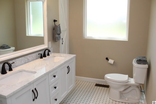 full bathroom featuring toilet, a sink, and a wealth of natural light