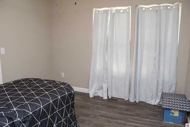 bedroom featuring baseboards and dark wood-style flooring