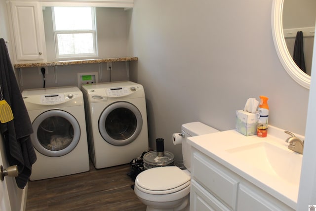 half bath featuring washing machine and dryer, toilet, vanity, and wood finished floors