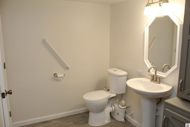 bathroom featuring wood finished floors, toilet, and baseboards