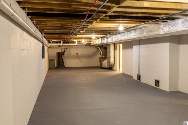 unfinished basement featuring water heater and electric panel