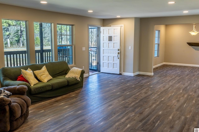 living area featuring recessed lighting, dark wood-type flooring, and a healthy amount of sunlight
