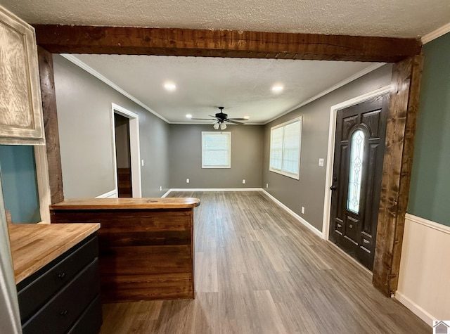 entrance foyer with ornamental molding, a ceiling fan, and wood finished floors