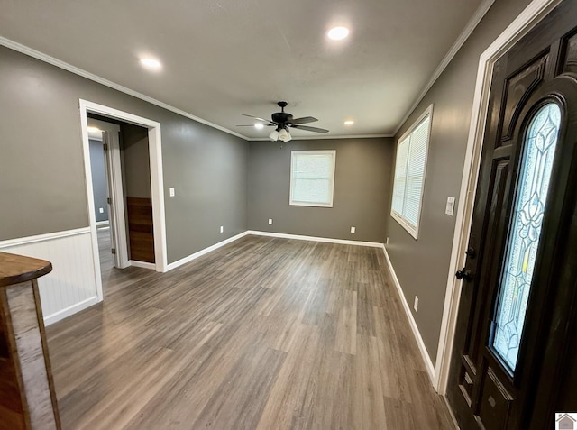entrance foyer featuring wood finished floors, ornamental molding, baseboards, and ceiling fan
