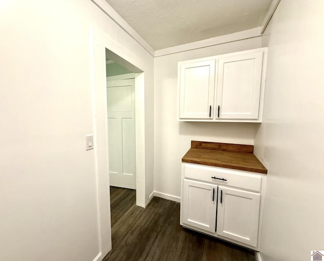 hallway with dark wood finished floors and baseboards