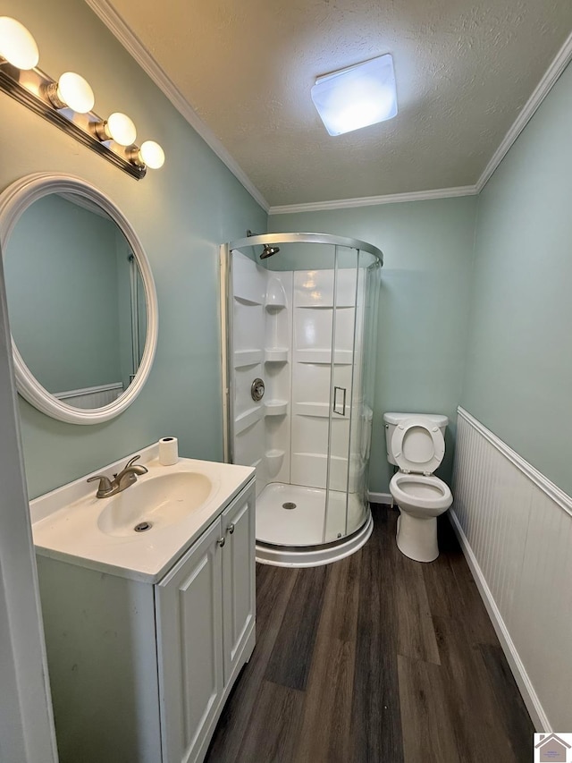 bathroom featuring a shower stall, toilet, vanity, and wood finished floors