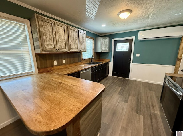 kitchen featuring dishwasher, a wall unit AC, ornamental molding, and a sink