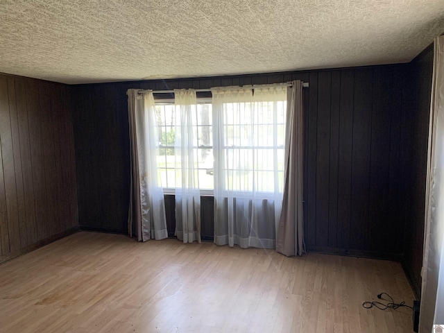 1368 Pritchard Rd, Wingo, KY 42088 - unfurnished room featuring wooden walls, wood finished floors, and a textured ceiling