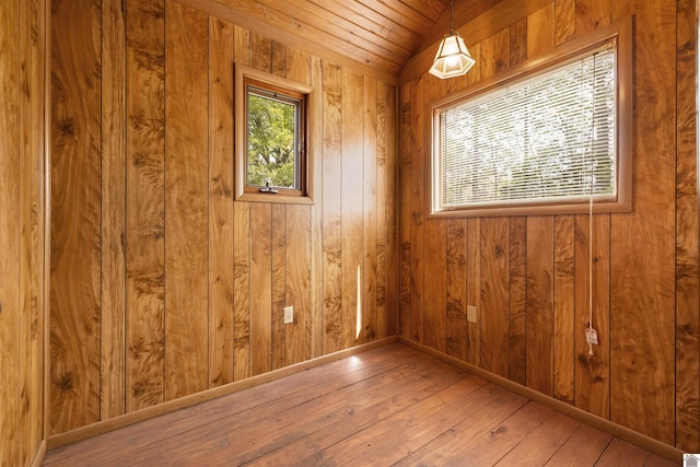 unfurnished room with wooden walls and hardwood / wood-style flooring