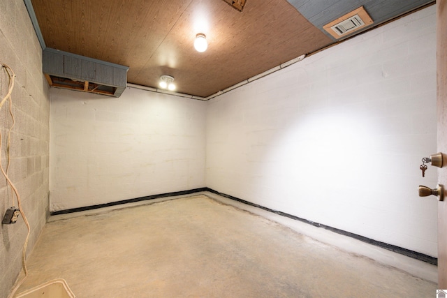below grade area with wood ceiling, concrete block wall, and visible vents