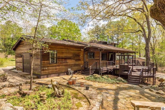 rear view of property featuring a deck and a patio