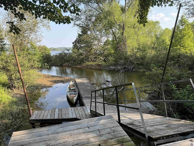 dock area with a forest view and a water view