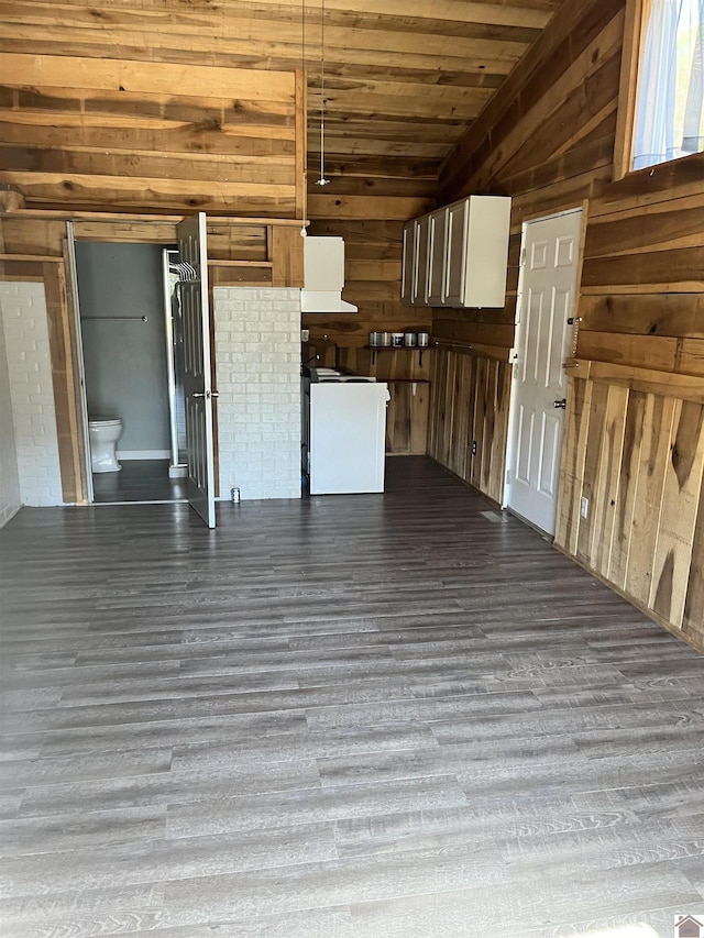 unfurnished living room featuring wooden ceiling, dark wood-type flooring, and wooden walls