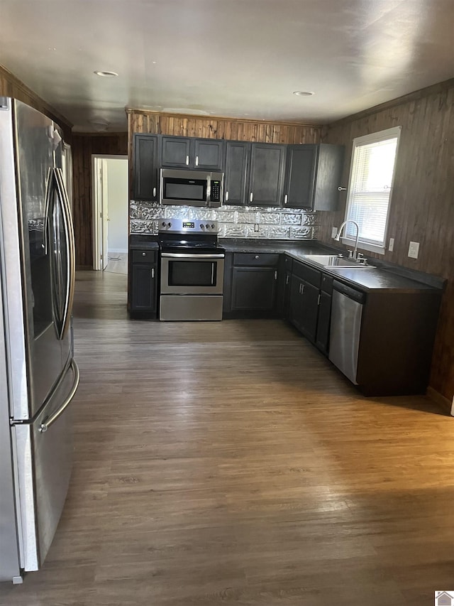 kitchen with dark countertops, appliances with stainless steel finishes, dark wood-style flooring, and a sink