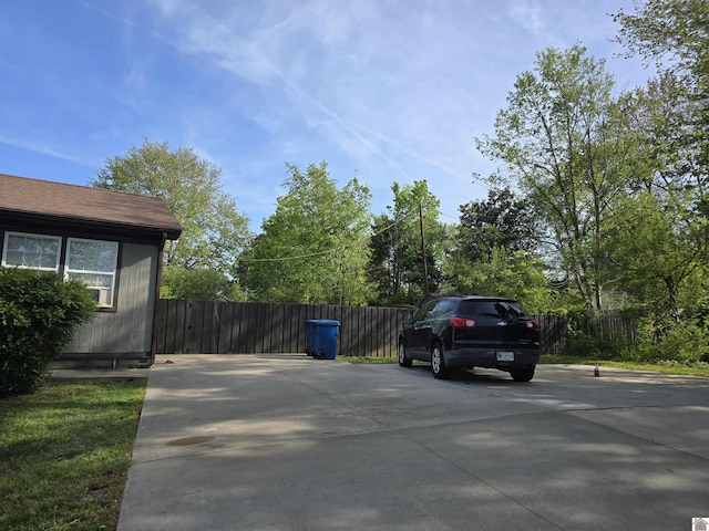 view of parking / parking lot featuring fence