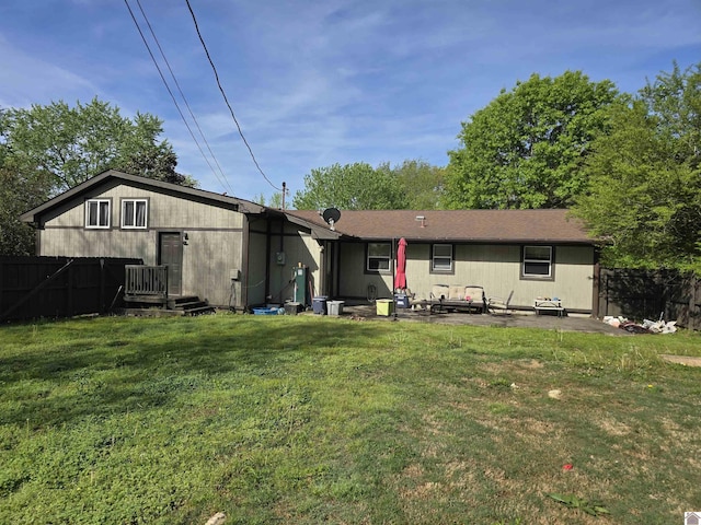 back of property featuring a lawn, a patio, and fence