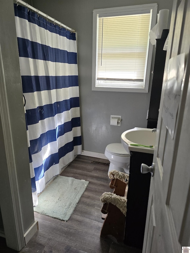 full bathroom featuring a shower with curtain, wood finished floors, vanity, and toilet