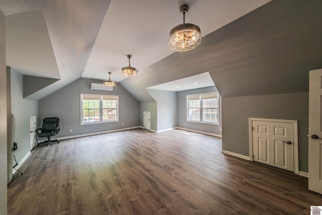 additional living space with dark wood finished floors, vaulted ceiling, baseboards, and an inviting chandelier