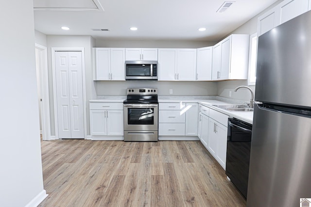 kitchen with a sink, light wood-type flooring, visible vents, light countertops, and appliances with stainless steel finishes